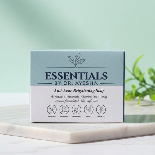 Box of Essentials by Dr. Ayesha Anti-Acne Brightening Soap on a light surface with a green background