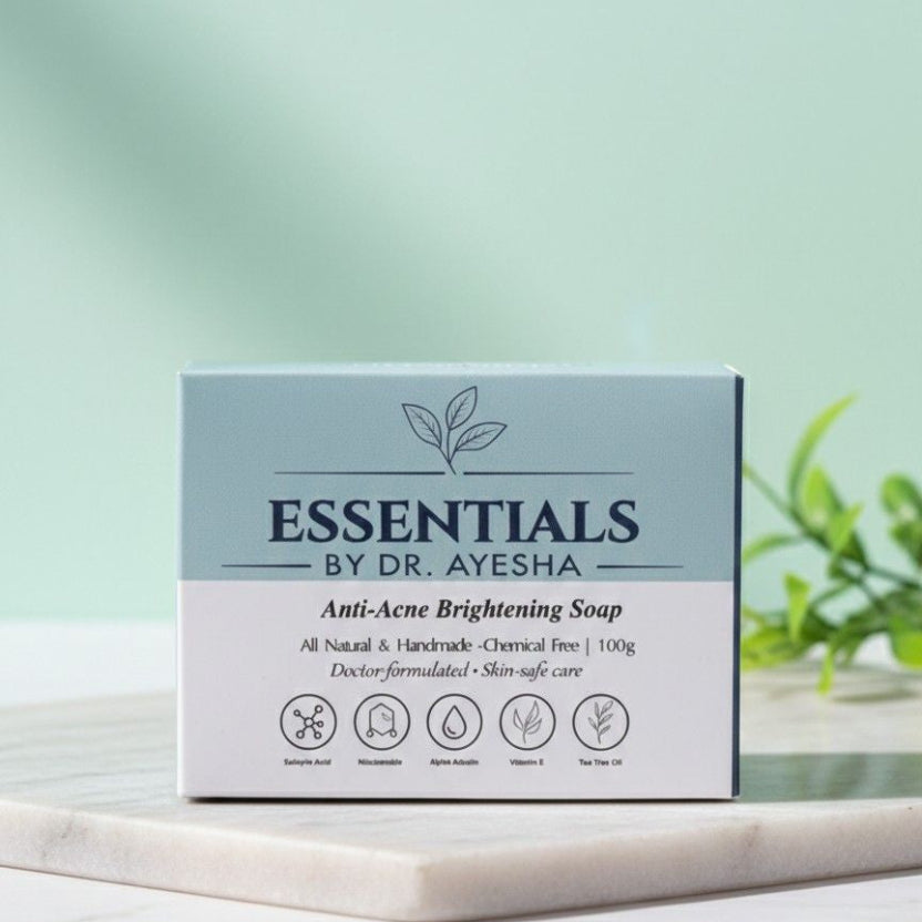 Box of Essentials by Dr. Ayesha Anti-Acne Brightening Soap on a light surface with a green background