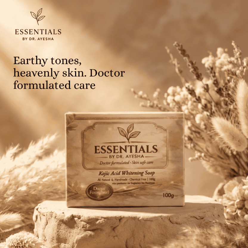 Soap bar with 'Essentials by Dr. Ayesha' packaging on a stone surface with dried plants, promoting natural skincare.