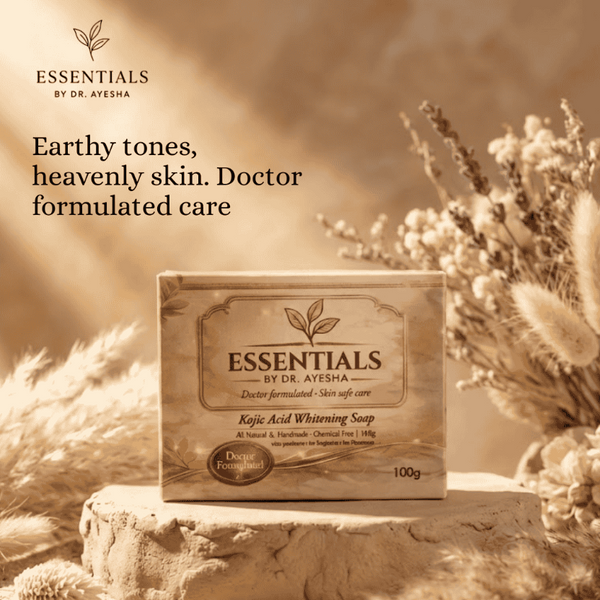 Soap bar with 'Essentials by Dr. Ayesha' packaging on a stone surface with dried plants, promoting natural skincare.